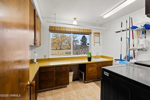 a view of a kitchen with kitchen island a sink a stove and a window