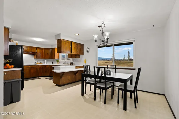 a large kitchen with a table and chairs
