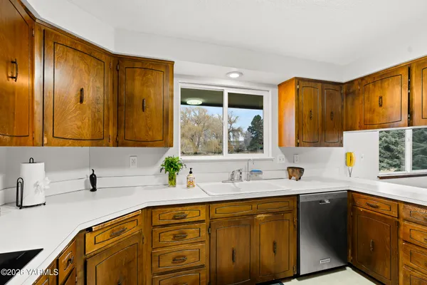 a kitchen with a sink a counter top space and stainless steel appliances