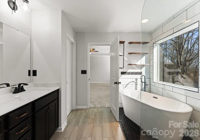 a large bathroom with a double vanity sink a mirror and a bathtub