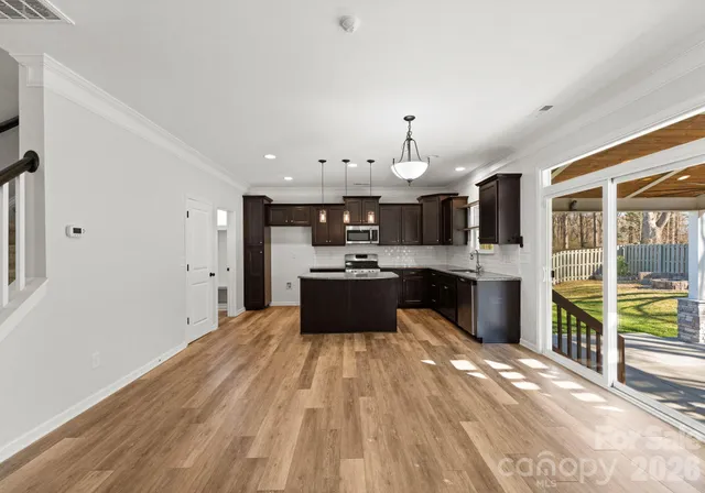 a large kitchen with kitchen island a sink dishwasher stove and white cabinets