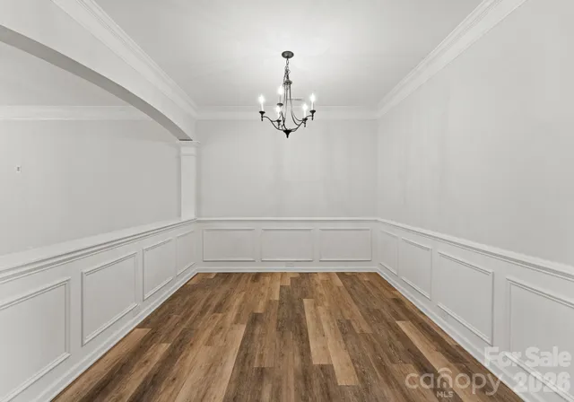 a view of a room with wooden floor closet and chandelier