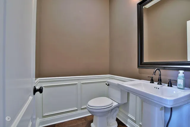 a bathroom with a granite countertop toilet a sink and a mirror