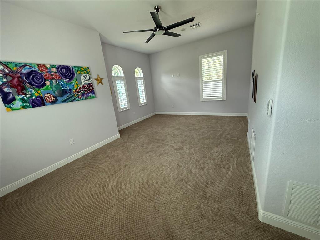 13110 Bamboo Street Spring Hill, FL 34609 - Photo 21 of 56 en empty room with windows and ceiling fan