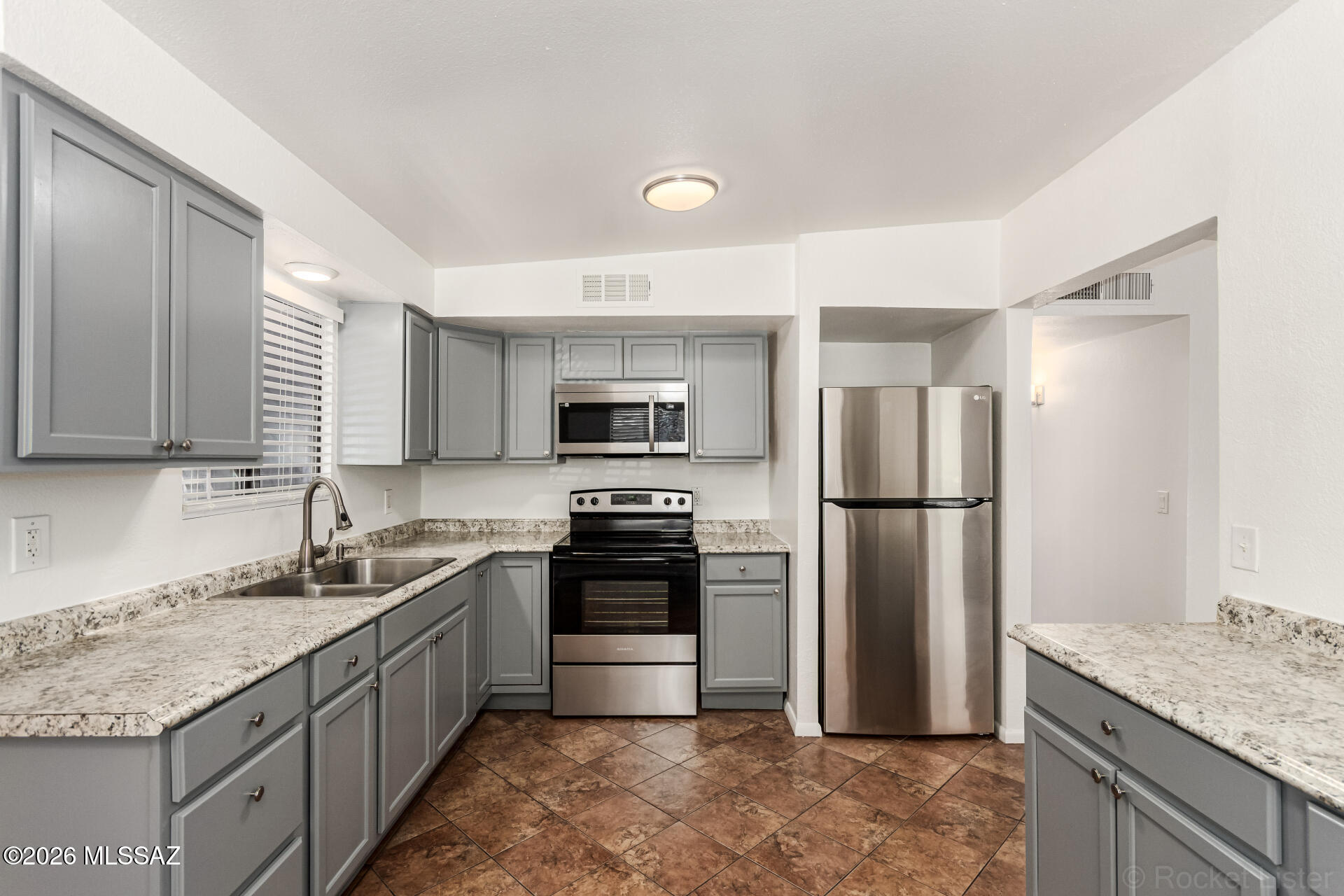 17 East Los Reales Road Tucson, AZ 85756 - Photo 5 of 27 a kitchen with stainless steel appliances granite countertop a sink stove and refrigerator