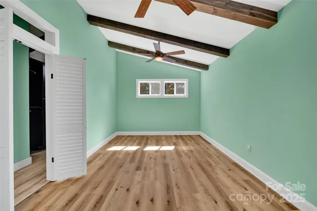 a view of a room with wooden floor and a ceiling fan