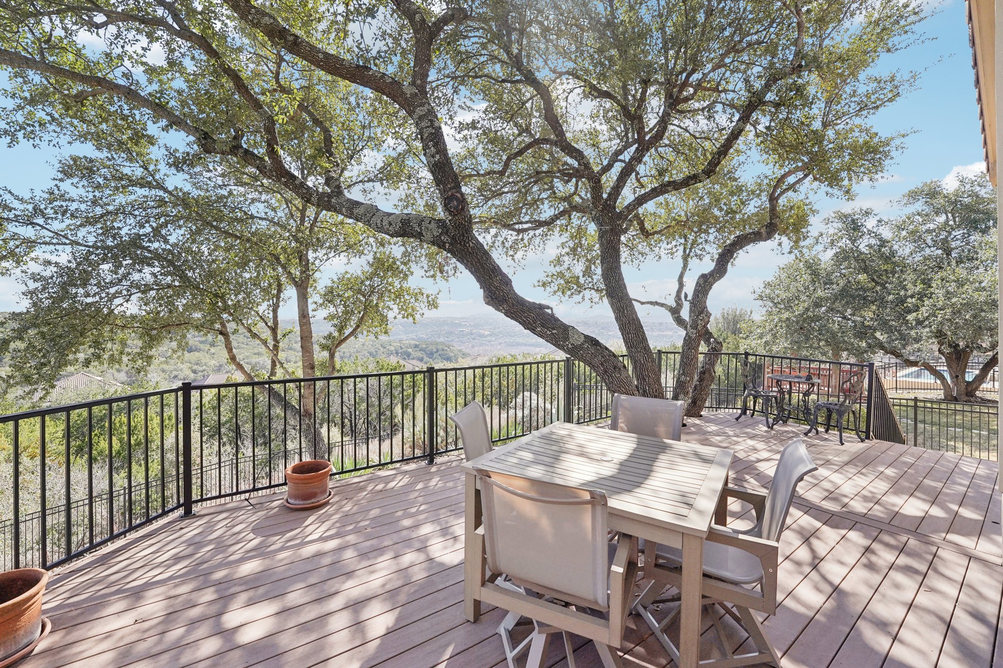 a view of a patio with a table chairs and a barbeque