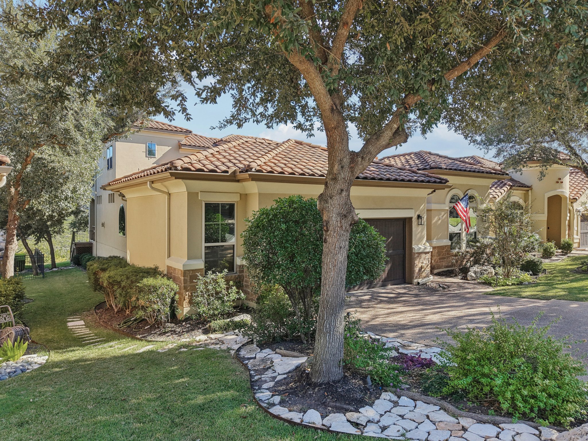 11613 Shadestone Terrace Austin, TX 78732 - Photo 2 of 34 a front view of a house with garden