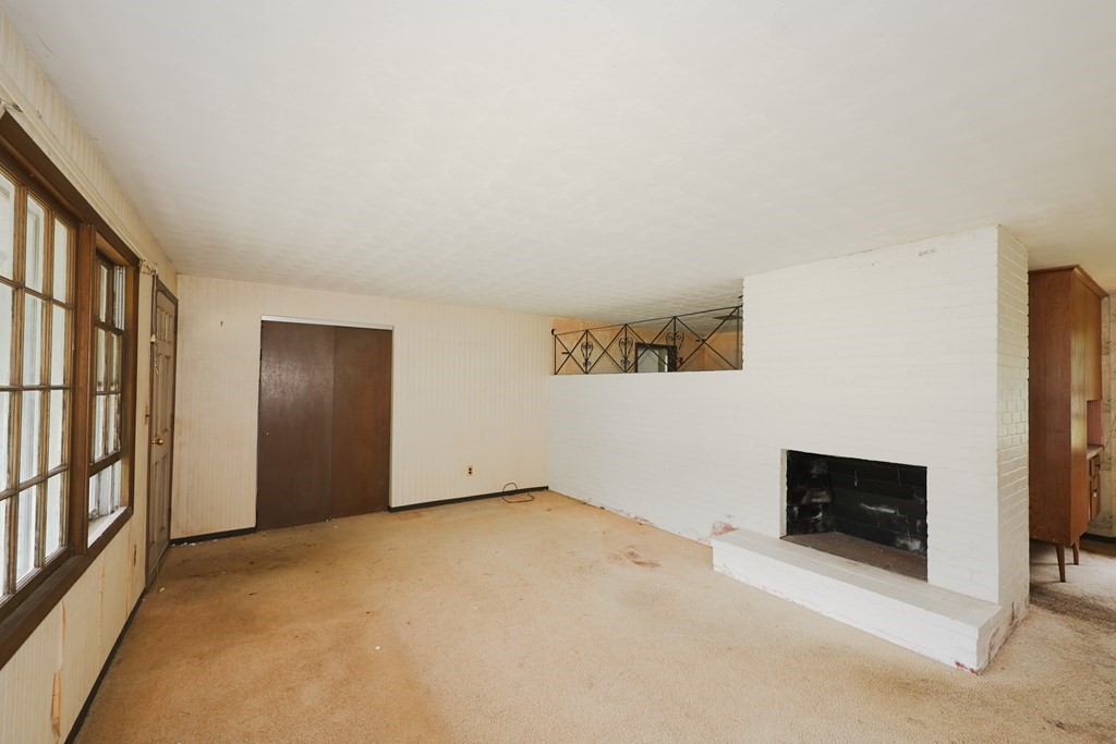 27 Trinity Street Danvers, MA 01923 - Photo 13 of 19 a view of an empty room with a fireplace and a window
