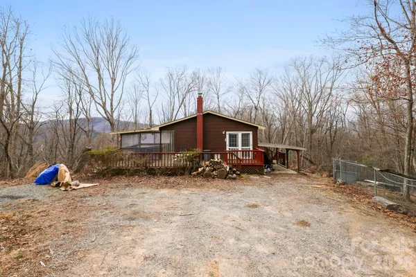 a view of a house with a small yard and wooden fence