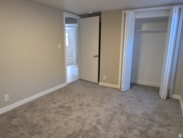 2880 Merton Way Magna, UT 84044 - Photo 17 of 30 Neutral tone walls with white trim, gray carpet flooring, and a bi-fold door closet