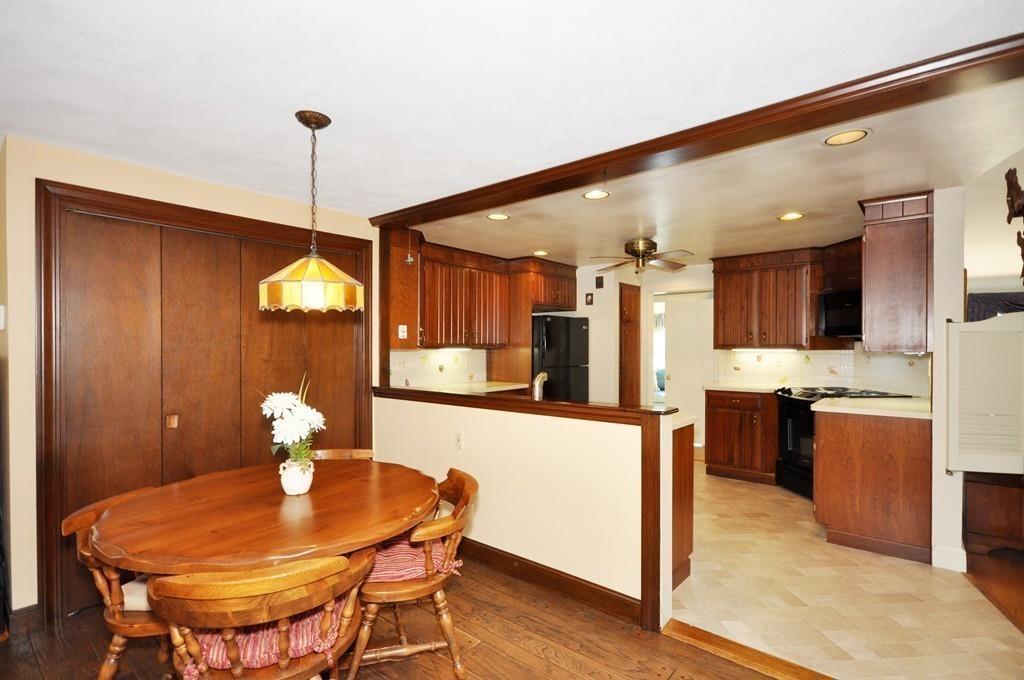 17 Cox Road Winchester, MA 01890 - Photo 7 of 19 a kitchen with stainless steel appliances kitchen island granite countertop a table chairs and a refrigerator
