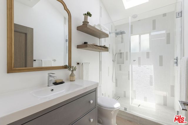 a bathroom with a sink toilet double vanity and shower