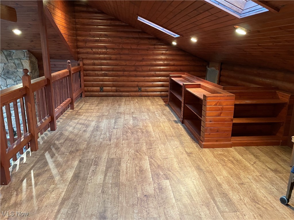 74068 Lake Ridge Road Piedmont, OH 43983 - Photo 11 of 45 Additional living space with high vaulted ceiling, wood ceiling, hardwood / wood-style flooring, rustic walls, and a skylight