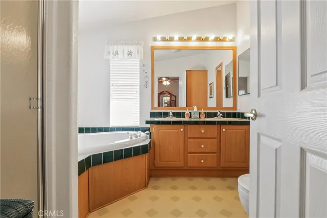 a bathroom with a tub a sink and a large mirror