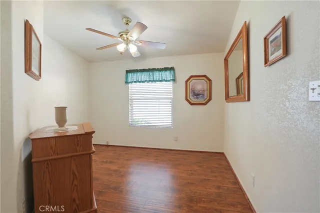 a view of a livingroom with wooden floor and a ceiling fan