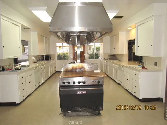 a large kitchen with stainless steel appliances granite countertop a stove and a sink