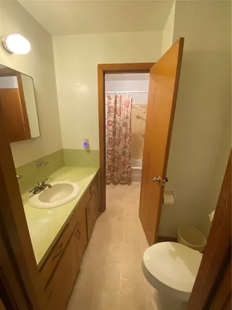 a bathroom with a sink mirror vanity and toilet