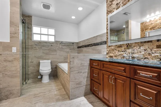 a bathroom with a toilet a sink and mirror