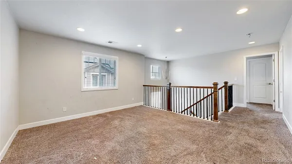 an empty room with a ceiling fan and window