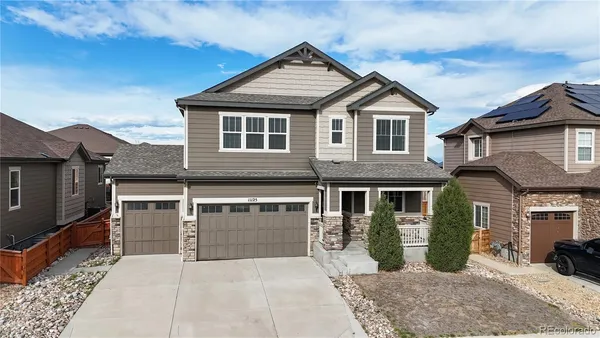 a front view of a house with yard and parking