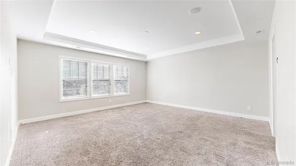 an empty room with windows and cabinet