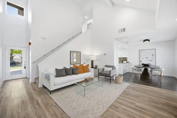 a living room with furniture and a wooden floor