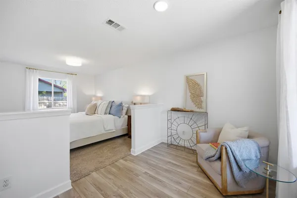 a bedroom with a bed and wooden floor