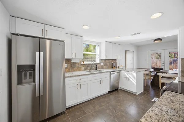 a kitchen with sink refrigerator and cabinets