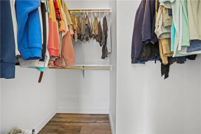 a view of walk in closet with clothes and shoes