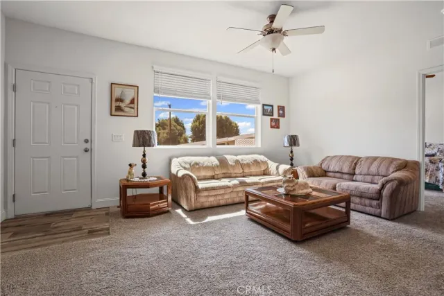 a living room with furniture kitchen view and a chandelier