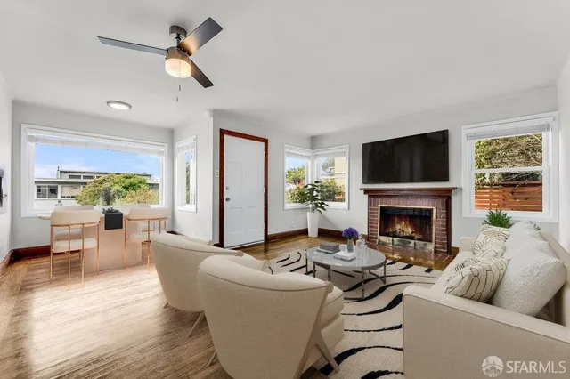 a living room with furniture fireplace and a large window