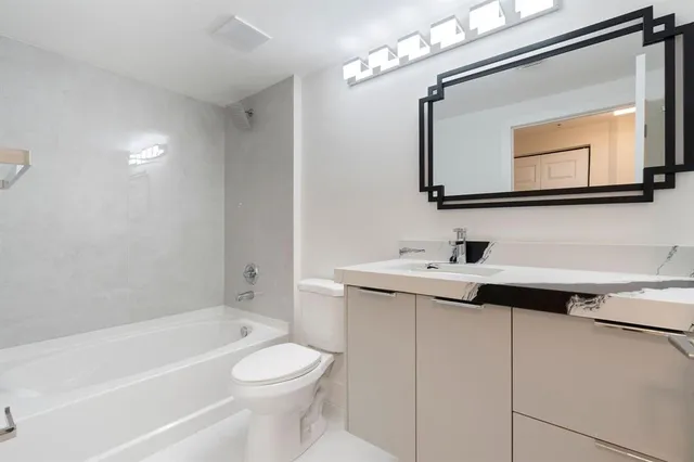a bathroom with a sink vanity toilet and a mirror