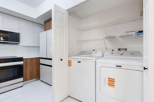 a kitchen with stainless steel appliances white cabinets and a refrigerator