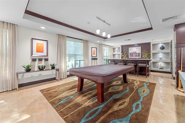 a living room with furniture a table and kitchen view