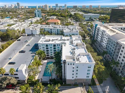 an aerial view of a city with lots of residential buildings ocean and mountain view in back
