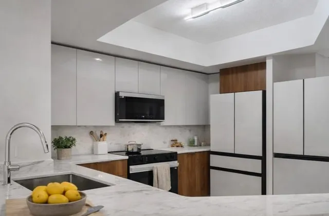 a view of a kitchen with stainless steel appliances wooden floor