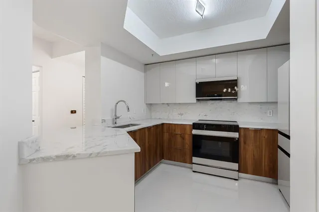 a kitchen with stainless steel appliances granite countertop a sink and a stove top oven with granite countertops
