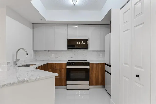 a kitchen with a sink and a stove top oven
