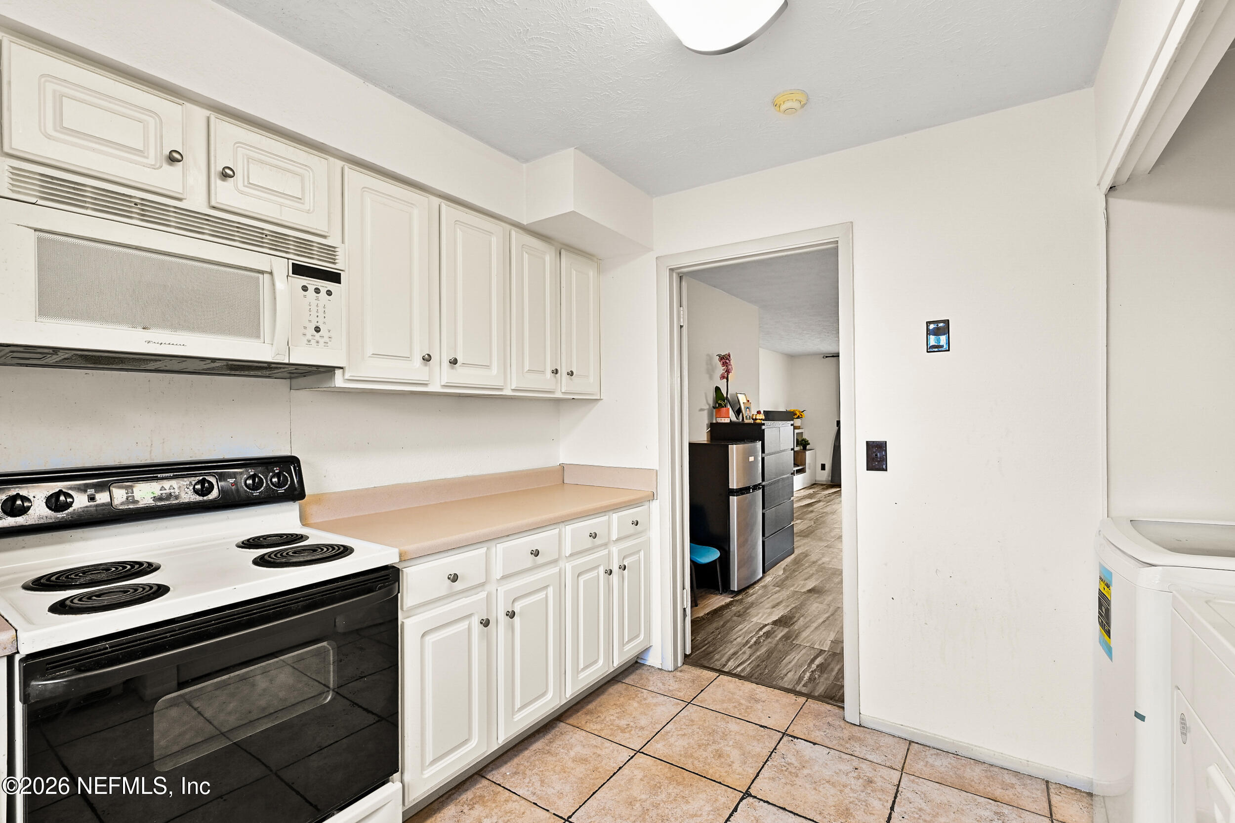 4915 Baymeadows Road, Unit 6G Jacksonville, FL 32217 - Photo 15 of 44 a kitchen with white cabinets and appliances