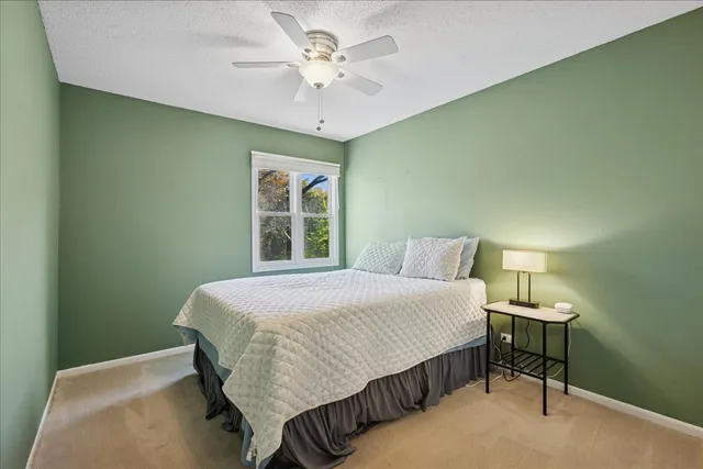 a bedroom with a bed chandelier and a window