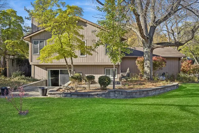 a view of a house with backyard sitting area and garden