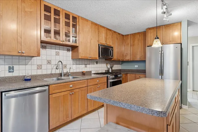 a kitchen with stainless steel appliances granite countertop a sink refrigerator stove microwave and cabinets