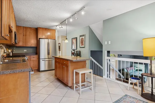 a kitchen with stainless steel appliances granite countertop a refrigerator and a stove top oven