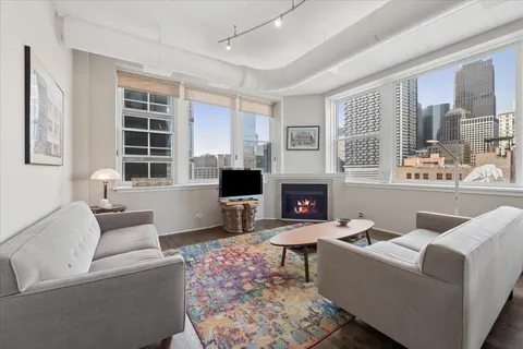 a living room with furniture a fireplace and a table