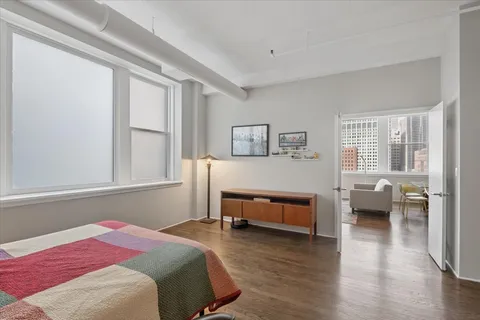a bedroom with a bed and wooden floor