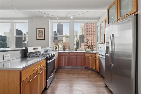 a kitchen with stainless steel appliances granite countertop a refrigerator and a stove