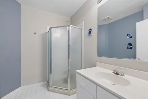 a bathroom with a shower sink and mirror