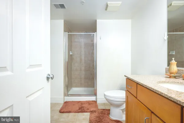 a bathroom with a granite countertop sink toilet and shower
