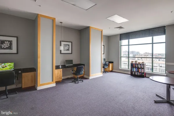 a view of a livingroom with workspace and a window
